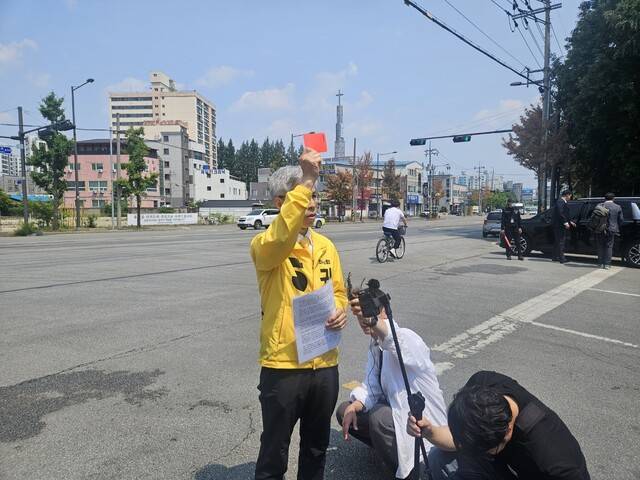 권영국 민주노동당 대통령 후보가 29일 오후 광주 광산구 금호타이어 광주공장 앞에서 기자회견을 열고 이준석 개혁신당 후보에게 레드카드를 들어 보이며 경고를 하고 있다. 류석우 기자