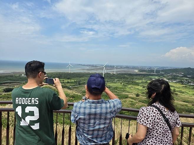 22일 대만 먀오리현 ‘허우룽 희망봉’에서 관광객들이 해안가 풍력발전기를 배경으로 사진을 찍고 있다. 옥기원 기자 ok@hani.co.kr