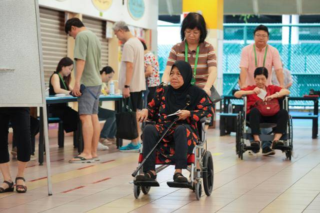 싱가포르 총선이 열린 이달 3일 거동이 불편한 유권자들이 휠체어를 타고 투표소로 들어오고 있다. 싱가포르=AP 연합뉴스