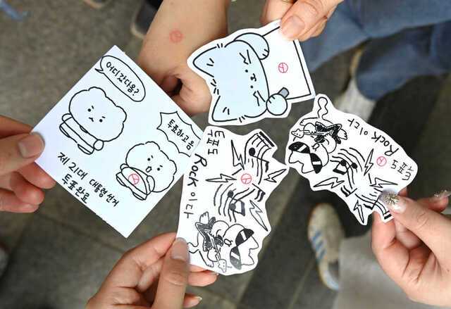 유권자들이 제21대 대통령 선거 사전투표 이틀째인 30일 경기 수원시청 별관에 마련된 사전투표소에서 한 표를 행사한 뒤, 기표 도장을 찍은 캐릭터 그림을 들고 인증사진을 찍고 있다. 뉴시스