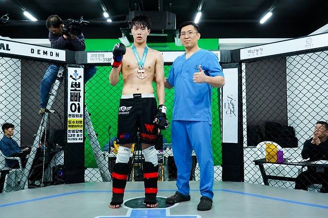 5월24일 KMMA 30회 대회에서 승리한 김호진(왼쪽)에게 뽀빠이연합의원 김성배 원장이 시상하고 있다. 사진=스탠다드앤드프로그레스 스포츠에이전시 제공