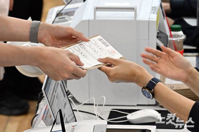 제21대 대통령선거 사전투표가 시작된 29일 오전 서울 마포구 용강동주민센터에 마련된 투표소에서 유권자가 투표용지를 전달받고 있다. 위 사진은 아래 기사와 직접적인 관련 없음. 윤창원 기자