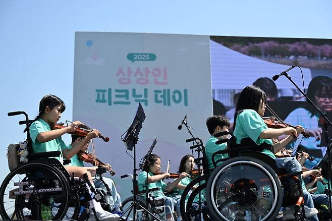 상상인그룹이 지난 26일 경기도 하남 미사경정공원에서 개최한 ‘2025 상상인 피크닉 데이’에서 ‘상상휠하모니 오케스트라’가 축하 공연을 하고 있다. (사진=상상인그룹)