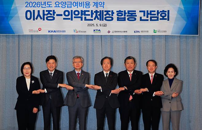 정기석(가운데 오른쪽) 건강보험공단 이사장과 김택우 대한의사협회 회장이 지난 9일 서울 마포구 서울가든호텔에서 열린 2026년도 요양급여비용 계약 이사장-의약단체장 합동간담회에서 참석한 의약단체장들과 함께 기념촬영을 하고 있다./연합뉴스