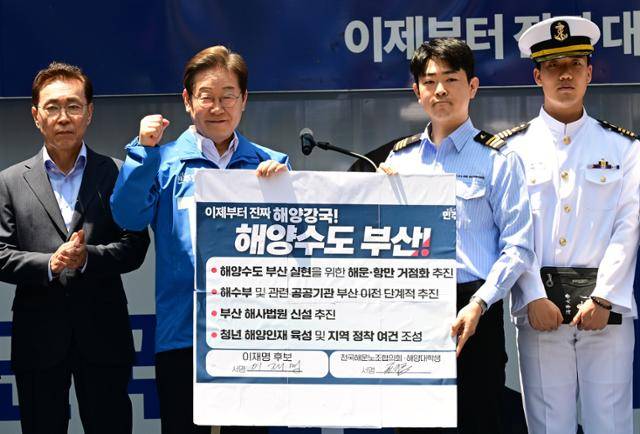 이재명(왼쪽 두 번째) 더불어민주당 대통령 후보가 민주당 험지로 꼽히는 부산·경남(PK) 지역 유세에 나선 지난 14일 부산 부산진구 서면에서 권기흥 에이치라인해운해상직원노조 위원장과 해양수도 부산 협약서에 서명한 뒤 들어보이고 있다. 부산=고영권 기자