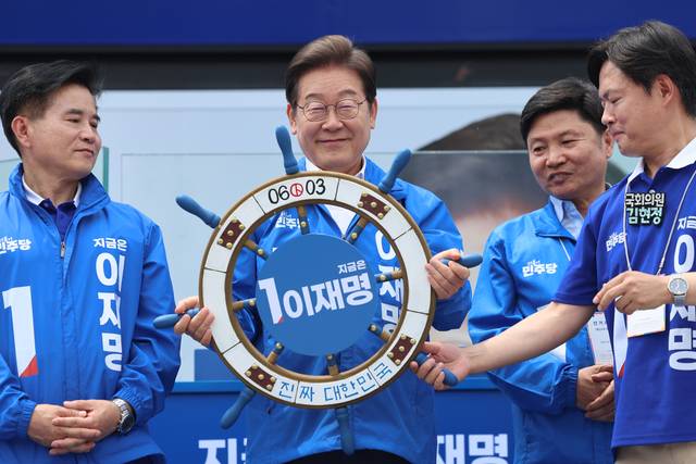 이재명 더불어민주당 대선 후보가 선거를 사흘 앞둔 마지막 주말인 31일 경기 평택시 배다리생태공원에서 열린 평택·오산·안성시 유세에서 조타기 받아 들어보이고 있다. 연합뉴스,