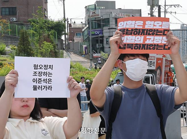 이준석 개혁신당 대선 후보가 지난달 30일 서울 동작구 중앙대학교에서 유세 중인 가운데 일부 학생들이 최근 이 후보의 TV토론 여성 신체 관련 발언을 규탄하며 팻말을 들고 있다. 정지윤 선임기자
