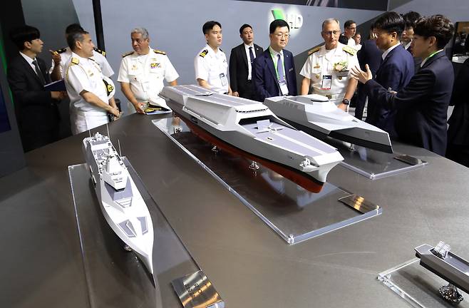 지난달 28일 부산 해운대구 벡스코 제1전시장에서 열린 2025 국제해양방위산업전(MADEX)에서 참가자들이 HD현대중공업 부스를 찾아 미래형 무인전력모함 등을 살펴보고 있다. 부산=뉴스1