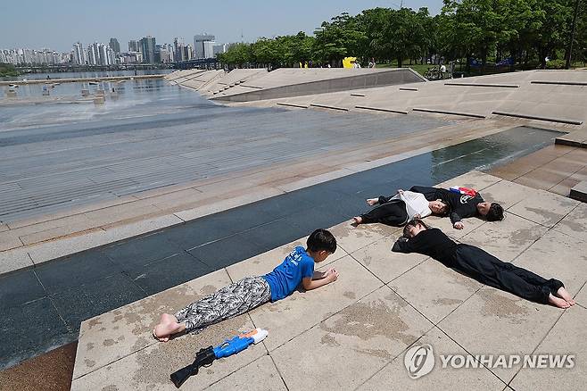 물놀이 쉬는 시간 (서울=연합뉴스) 신현우 기자 = 낮 동안 초여름 날씨를 보인 8일 서울 영등포구 여의도물빛광장을 찾은 어린이들이 물총놀이를 마친 뒤 잠시 휴식하고 있다. 2025.5.8 nowwego@yna.co.kr