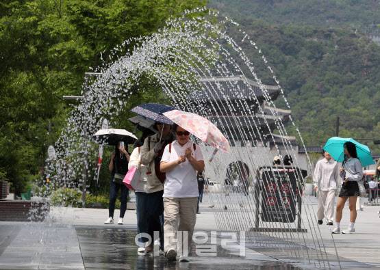 초여름 날씨를 보인 20일 오후 서울 광화문광장 분수터널에서 시민들이 더위를 식히고 있다.(사진=김태형 기자)