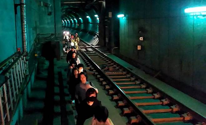 31일 오전 서울 지하철 5호선 마포역~여의나루역 구간을 지나는 열차에서 방화로 인한 화재가 발생, 승객들이 선로를 통해 대피하고 있다. /사진=뉴스1(영등포소방서 제공).