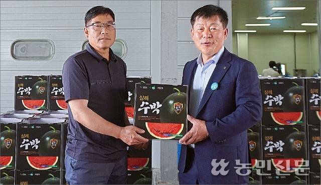 전북 완주 삼례농협 강신학 조합장(오른쪽)과 도두용 수박 공동선별출하회 총무가 출하식에서 ‘블랙위너’ 수박을 들어 보이고 있다.