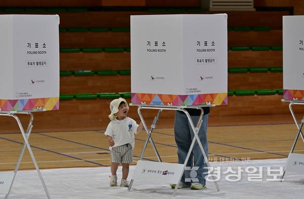 제21대 대통령 선거일인 3일 울산시 울주군 범서초등학교 체육관에 마련된 범서읍 제5투표소에서 미래의 유권자인 한 아이가 엄마의 투표모습을 지켜보고 있다. 김동수기자 dskim@ksilbo.co.kr