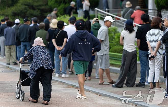 제21대 대통령 선거일인 3일 서울 영등포구 여의도 윤중중학교에 마련된 투표소를 찾은 시민들이 길게 줄 서 있다. 2025.6.3/뉴스1 ⓒ News1 이승배 기자