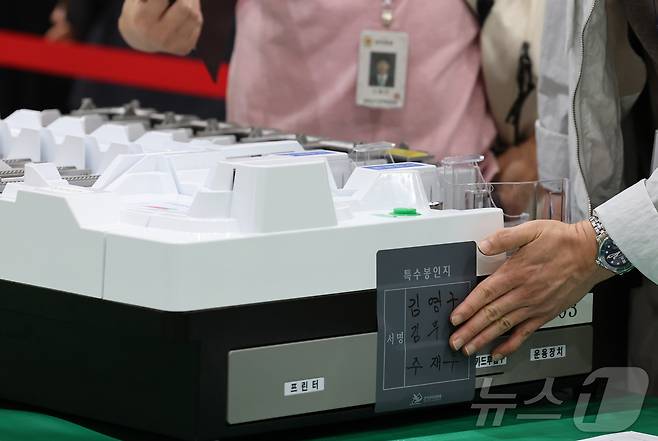 21대 대통령선거를 하루 앞둔 2일 대전 유성구 대전컨벤션센터에 마련된 개표소에서 유성구선관위 관계자들이 개표 준비 상황을 점검한 뒤 투표지 분류기에 봉인지를 부착하고 있다. 2025.6.2/뉴스1 ⓒ News1 김기태 기자