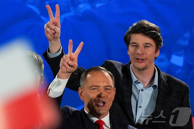 법과정의당(PiS) 소속인 폴란드 대통령 후보 카롤 나브로츠키가 아들 안토니와 함께 2025년 6월 1일 폴란드 바르샤바에서 대통령 선거 2차 투표의 출구 조사 결과에 반응하며 승리의 손짓을 하고 있다. 2025.6.1 ⓒ 로이터=뉴스1 ⓒ News1 강민경 기자