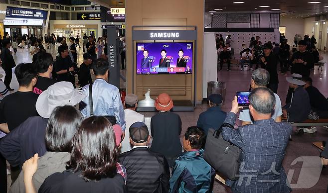 제21대 대통령 선거 투표일인 3일 오후 서울 중구 서울역에서 유권자들이 방송3사 출구조사 결과를 TV와 스마트폰으로 확인하고 있다. 2025.6.3/뉴스1 ⓒ News1 김진환 기자
