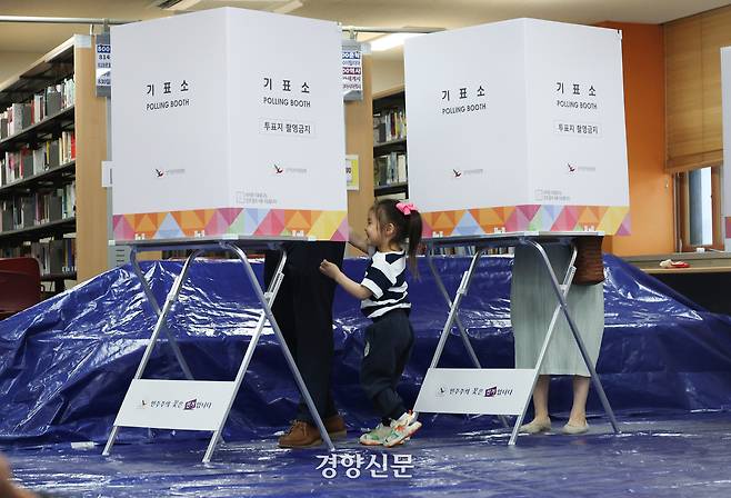 제21대 대통령 선거일인 3일 서울 영등포구 윤중중학교에 마련된 여의동제7투표소에서 한 어린이가 보호자와 함께 기표소에 들어가고 있다. 권도현 기자