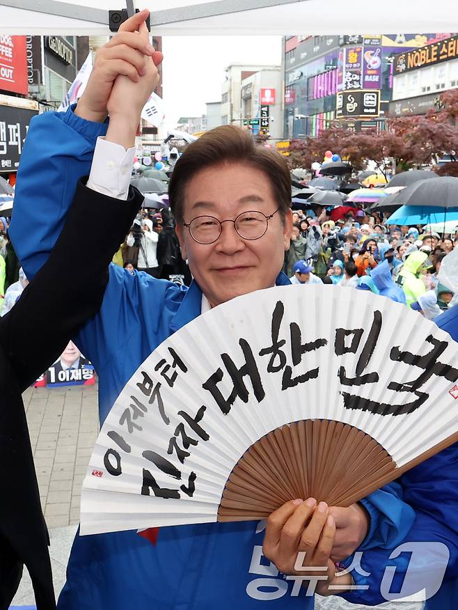 이재명 더불어민주당 대통령 후보가 16일 오후 전북 전주시 전북대학교 앞에서 '이제부터 진짜 대한민국'이 적힌 전주 한지 부채(합죽선)를 들어보이고 있다. (공동취재) 2025.5.16/뉴스1 ⓒ News1 이재명 기자