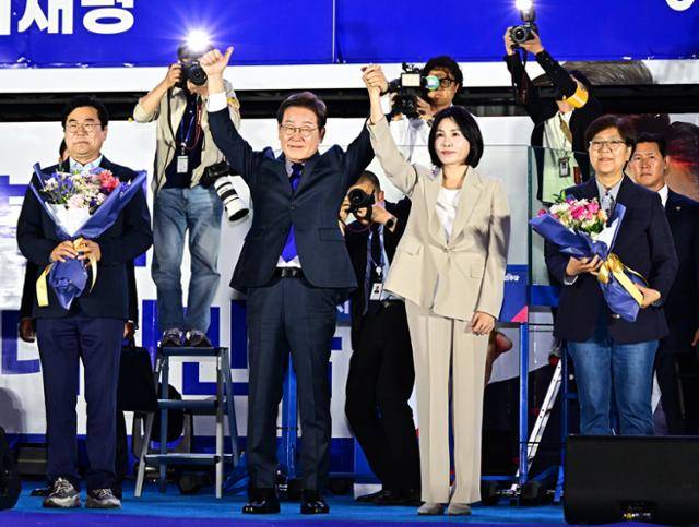 제21대 대통령 당선 확정을 앞두고 이재명(앞줄 왼쪽 두 번째) 더불어민주당 대선 후보와 배우자 김혜경(세 번째) 여사가 4일 오전 서울 여의도 국회 인근에서 당 주최로 열린 국민개표방송 행사에 참석해 시민들을 향해 인사하고 있다. 연합뉴스