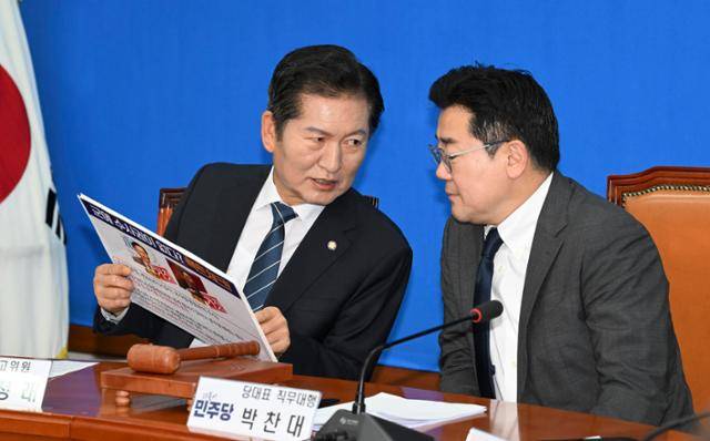 박찬대(오른쪽) 더불어민주당 당대표 직무대행 겸 원내대표와 정청래 최고위원이 5일 국회에서 열린 최고위원회의에서 서영교 최고위원이 준비한 자료를 두고 얘기를 나누고 있다. 정다빈 기자