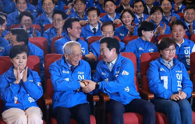 Democratic Party floor leader Park Chan-dae (second from right) shakes hands with Yoon Yeo-joon, head of the Democratic Party’s election campaign committee, as they wait to watch the exit polls at the National Assembly in western Seoul on Wednesday. (Yonhap)