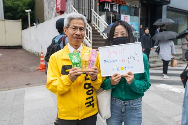 ▲ 2일 권영국 후보의 강남역 선거 유세 중 “페미니스트 대통령 실존”이라고 쓴 화이트보드를 들고 온 한 여성이 권 후보에게 사탕 꾸러미를 건넸다. 사진=민주노동당 홈페이지.