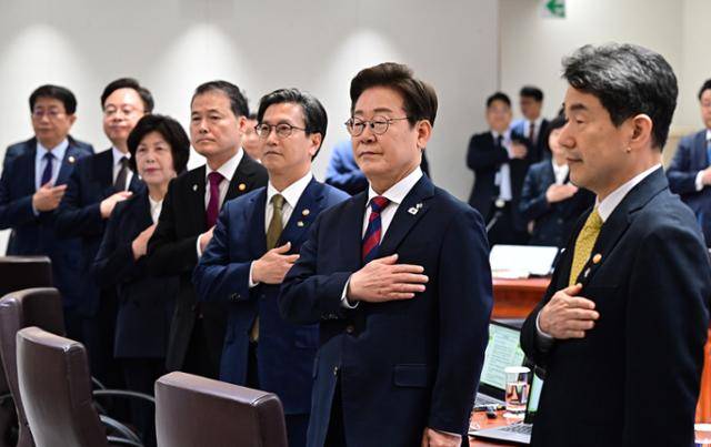 이재명 대통령이 5일 서울 용산 대통령실 청사에서 취임 후 열린 첫 국무회의에서 국민의례를 하고 있다. 옆에는 윤석열 정부에서 임명된 장관들이 어색한 표정으로 참석해 있다. 왕태석 선임기자