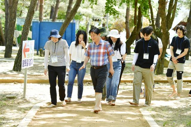 ▲ 최문순 화천군수와 7급 이하 공직자들이 5일 화천읍 붕어섬 황톳길에서 맨발로 함께 걸으며 대화를 나누고 있다.