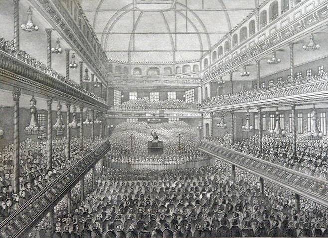 1898년 영국의 로얄서리가든의 서리 뮤직홀에서 설교하는 스펄전 목사를 그린 삽화입니다. 그는 기존 예배당에 청중을 수용할 수 없어 이곳에서 예배를 드리곤 했는데요. 무려 1만여명이 참석했다고 합니다. 여기서 예배를 인도할 당시 압사 사고가 나는 비극도 겪습니다. 위키미디어 커먼스