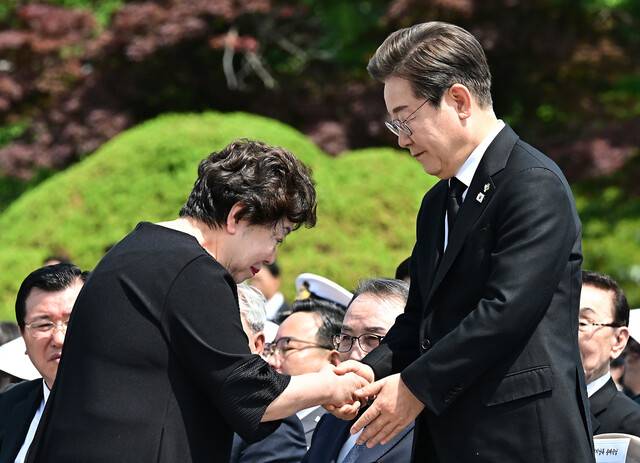 이재명 대통령이 6일 서울 동작구 국립서울현충원에서 열린 제70회 현충일 추념식에서 6·25 전쟁 전사자 고 송영환 일병의 딸 송재숙씨와 악수하고 있다. 대통령실사진기자단