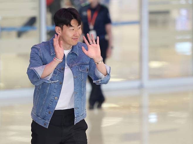 Son Heung-min waves at the fans after arriving at the Incheon International Airport on May 27. (Yonhap)