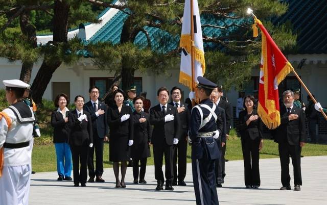 이재명 대통령과 부인 김혜경 여사가 지난 4일 서울 동작구 국립서울현충원 현충탑 참배를 위해 들어서며 국기에 경례를 하고 있다. 뉴시스