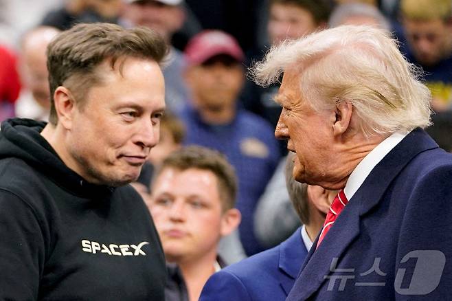 일론 머스크 테슬라 최고경영자(CEO)가 2025년 3월 22일 미국 펜실베이니아주 필라델피아에서 열린 NCAA 남자 레슬링 챔피언십에 참석한 도널드 트럼프 미국 대통령을 맞이하고 있다. ⓒ 로이터=뉴스1 ⓒ News1 권영미 기자