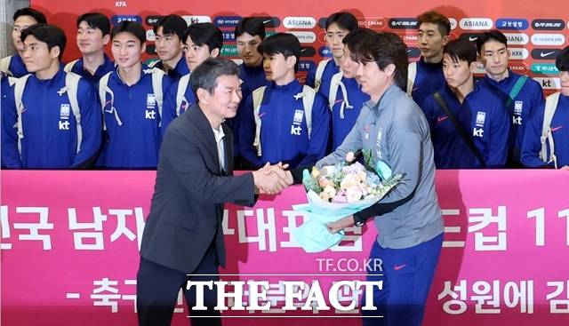 한국축구대표팀의 홍명보 감독(오른쪽)이 이라크 원정 경기에서 승리해 2026 북중미 월드컵 본선 진출에 성공한 뒤 인천국제공항을 통해 귀국, 정몽규 대한축구협회장으로부터 월드컵 11회 연속 본선 진출을 축하하는 꽃다발을 전달받고 있다./뉴시스