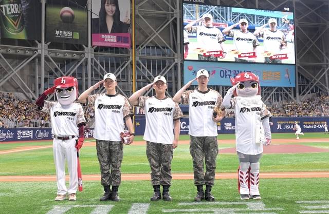 국방부는 호국보훈의 달을 맞아 6일 현충일, 고척 스카이돔에서 키움 히어로즈 프로야구단과 협업하여 3대째 군인의 길을 걷고 있는 육·해·공군 초급 장교들의 시구·시타•시포 행사를 진행했다. 왼쪽부터 시포자 해군 주민서 소위, 시타자 육군 백승 소위, 시구자 공군 김기현 중위가 시구에 앞서 국민들께 경례하고 있다. 국방부 제공