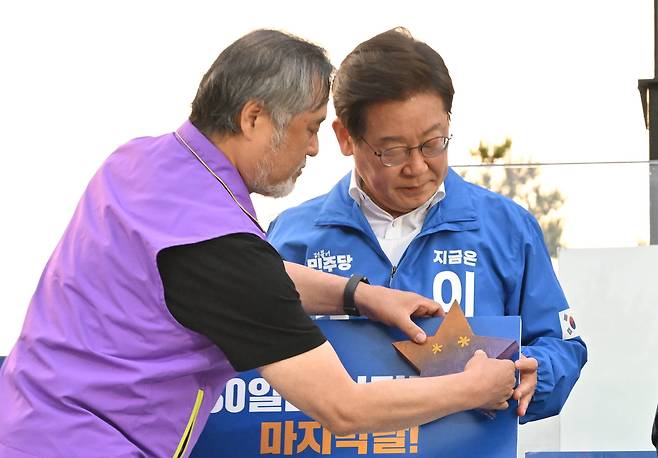 이재명 더불어민주당 대선 후보가 29일 오후 서울 관악구 관악산으뜸공원에서 열린 유세에서 이태원참사 유가족으로부터 진실의 별을 전달받고 있다. 임세준 기자
