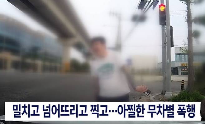 택시기사를 도로로 밀치고 웃음을 보이는 A씨. (사진=KNN 유튜브 갈무리)