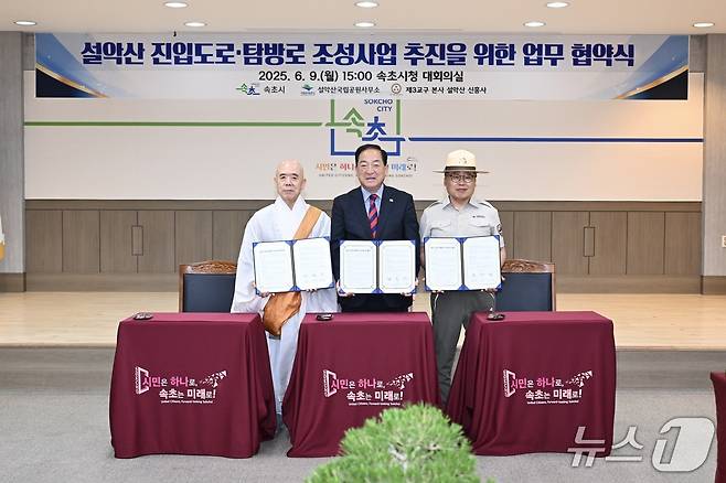9일 오후 강원 속초시청 대회의실에서 열린 설악산 '진입도로·탐방로 조성을 위한 관계기관 협약식'에서 이병선 시장(사진 가운데)과 대한불교 조계종 제3교구 본사 신흥사 주지 스님(사진 왼쪽), 현병관 국립공원공단 설악산사무소장이 협약서를 들고 기념촬영을 하고 있다.(속초시 제공, 재판매 및 DB 금지) 2025.6.9/뉴스1
