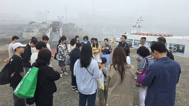 수영로교회 교인들이 8일 안개로 인해 수우도로 가는 배편이 지연돼 안개가 걷히길 기다리며 기도하고 있다. 수영로교회 제공