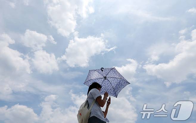 30도 안팎의 낮더위가 이어지고 있는 서울 광화문광장에서 파란하늘 아래 양산을 쓴 시민들이 연휴를 만끽하고 있다. 2025.6.8/뉴스1 ⓒ News1 이동해 기자
