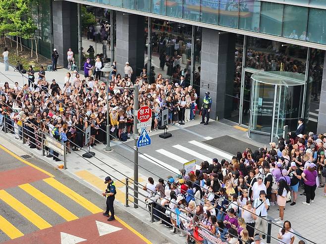 BTS fans gather outside Hybe's headquarters in Yongsan-gu, Seoul, on Tuesday, as RM and V are discharged from the military. (Hybe)