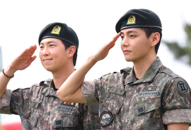 육군 현역 복무를 마치고 만기 전역한 그룹 방탄소년단(BTS) 뷔(오른쪽)와 RM이 10일 강원 춘천시 신북읍체육공원에서 거수경례하고 있다. 연합뉴스