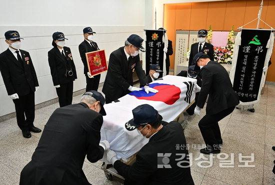 ▲ 대한민국 무공수훈자회 울산시지부 회원들이 10일 굿모닝병원 장례식장에서 6·25 참전용사로 국가유공자인 고인의 관 위에 대형 태극기를 덮는 관포식을 진행하고 있다. 김동수기자 dskim@ksilbo.co.kr