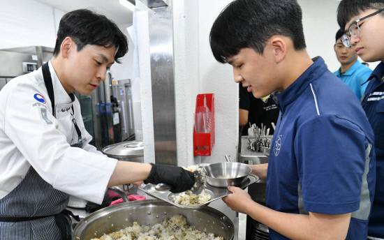 11일 공군교육사령부는 국내 수산물을 셰프가 직접 요리해 수준 높은 한끼 식사를 제공하는 행사인 '수산물 day'를 실시했다. 사진은 조성현 쉐프(왼쪽)가 직접 조리한 음식을 장병들에게 나눠주고 있는 모습. 사진=공교사
