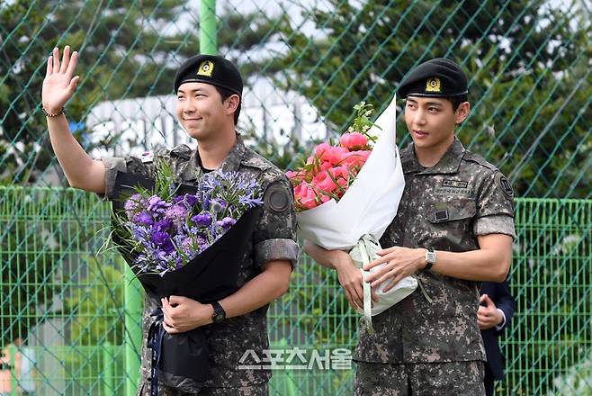 방탄소년단(BTS)의 RM(왼쪽, 김남준)과 뷔(김태형)이 10일 강원도 춘천시 신북읍 체육공원에서 진행된 전역 행사에서 팬들을 향해 인사를 하고 있다. RM은 육군 제15보병사단 군악대에서, 뷔는 2군단 군사경찰 특수임무대에서 1년 6개월 동안 군복무를 했다. 2025. 6. 10. 춘천 | 박진업 기자 upandup@sportsseoul.com
