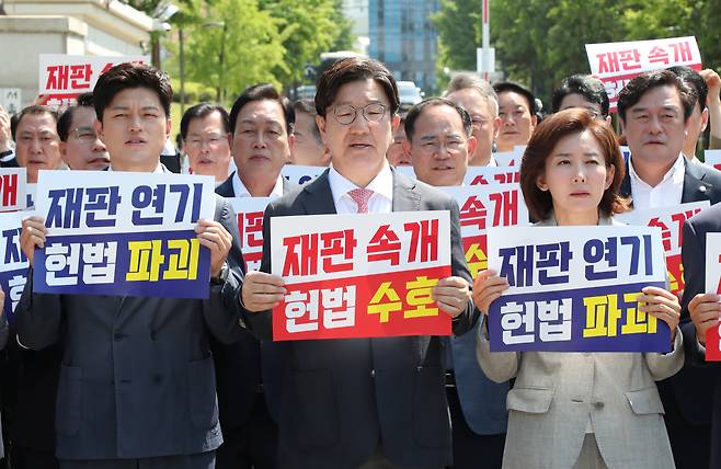 국민의힘 김용태 비상대책위원장과 권성동 원내대표 등 참석의원들이 11일 이재명 대통령의 공직선거법 위반 사건의 파기환송심을 사실상 무기한 연기한 서울고등법원 앞에서 열린 현장 의원총회에서 구호를 외치고 있다. /남강호 기자