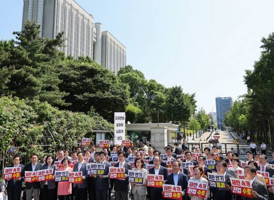 국민의힘 의원들이 11일 이재명 대통령의 공직선거법 위반 사건의 파기환송심을 사실상 무기한 연기한 서울고등법원 앞에서 열린 현장 의원총회에서 구호를 외치고 있다. 연합뉴스