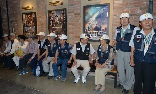 6·25 참전 비정규군인 8240부대(켈로부대·KLO)원과 유족들이 지난 2016년 8월18일 오후 서울 여의도 한 영화관에서 영화 '인천상륙작전'을 관람하기 앞서 포스터 앞에 앉아 대화나누고 있다. 오른쪽 네명 등은 무공수훈자다.(자료사진) 뉴시스