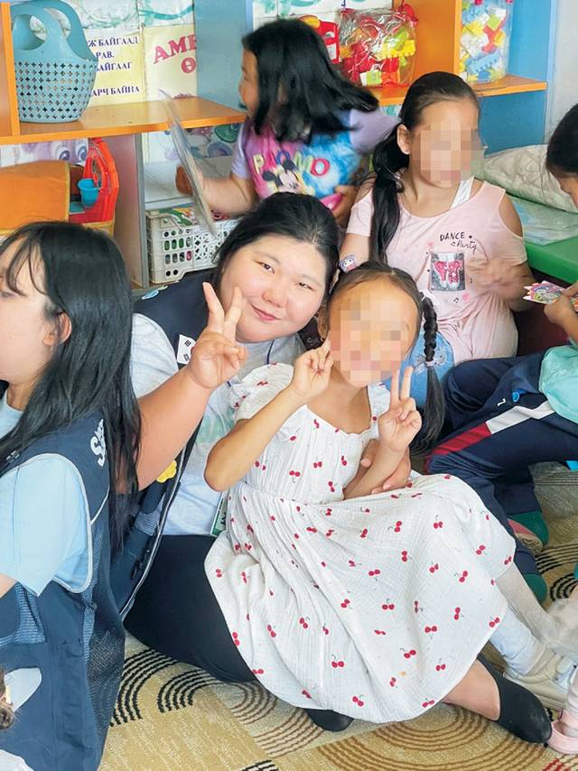 자원봉사자 조민경(왼쪽 첫 번째) 씨가 2024년 8월 7일 몽골에 방문해 화재 예방 교육을 실시한 후 보육원 아이들과 함께 사진을 촬영하고 있다. 초록우산 제공